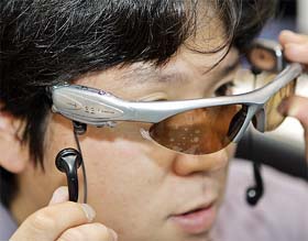An employee from Japanese optical maker Volks displays a pair of sunglasses with an MP3 digital audio player