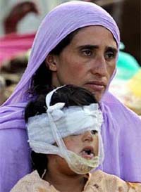 A woman holds her wounded child as she waits to be airlifted to a hospital in Muzaffarabad, capital of Pakistan-occupied Kashmir
