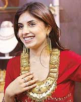 A customer tries out a gold necklace at a jewellery exhibition in New Delhi on Friday. Demand for gold in India, the worlds top consumer, is expected to pick up in the current festival season, traders say. 