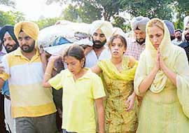 Daughters and wife of Additional Sessions Judge Vijay Singh carry the body of the slain judge to the cremation ground in Patiala, on Friday.