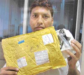 Mr Kailash Kumar, a resident of New Shivpuri locality, Ludhiana, shows the parcel from which a mobile phone set went missing