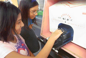 Girls with their hands in the computerised Nail Art machine