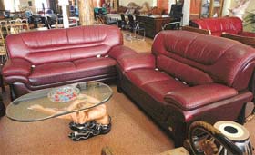 SIT IN STYLE: The sofa is a well of comfort upholstered in red and a hand holds the table glasstop