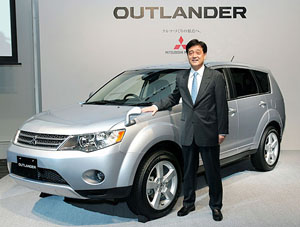 Mitsubishi Motors Corporation President Osamu Masuko poses with the companys new SUV, Outlander, at its headquarters in Tokyo on Monday.