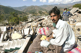 Earthquake survivor Shaoor Ahmed, who lost 11 family members in the earthquake, sits on the rubble of his home in Balakot, Pakistan.