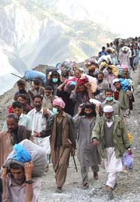 Evacuees walk along a road in Neelum Valley as they return to their mountain village of Divilain, about 30 km north of Muzaffarabad, capital of Pakistan-occupied Kashmir, on Monday.
