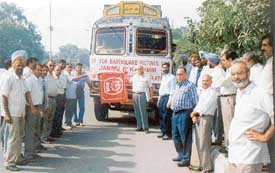 Bank employees flag off a truck carrying blankets to Srinagar for earthquake victims