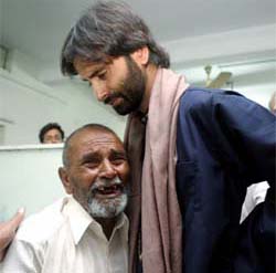 An elderly earthquake victim breaks down in tears as Yasin Malik, Chairman of the Jammu Kahsmir Liberation Front (JKLF), comforts him in a Rawalpindi hospital