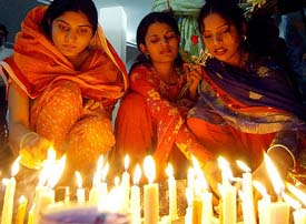Women light candles in remembrance of the earthquake victims in Lahore on Thursday