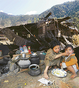 RENDERED HOMELESS: The quake has left many children to fend for themselves. Heres a young girl feeding her sibling amidst the ruins of their house in Kamal Kote, 130 km from Srinagar.