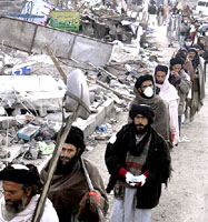 Pakistani volunteers line up to continue the search for dead bodies in Balakot on Friday