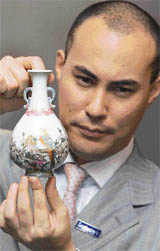 Head of Sothebys Chinese Ceramics Department Nicolas Chow displays a Qing porcelain Pheasant vase during a press conference following its sale in Hong Kong on Sunday