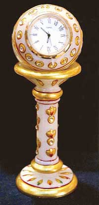 A clock on an embellished marble pedestal
