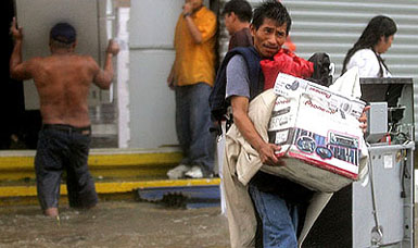 Looters carry new electronic equipment from a store after Hurricane Wilma hit the resort town of Cancun in Mexicos state of Quintana on Saturday 