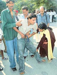 Rakesh, who was allegedly tortured by the police, is helped to stand by his mother in Chandigarh