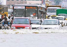 Vehicles move through a flooded road in Bangalore on Monday. 