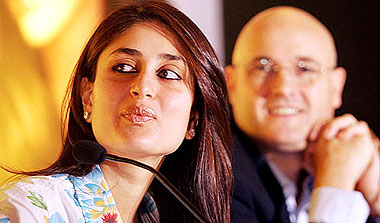 Kareena Kapoor watches a projection screen as General Manager, Garnier India, Phillippe Raffray, looks on in Mumbai on Wednesday