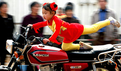 Four-year-old Tu Yuncai performs acrobatics on a motorcycle in Shijiazhuang, north China, on Wednesday