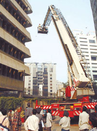 Delhi Fire Service personnel making a practice demonstration on how to control fire in a high-rise building at American Center, Connaught Place, in the Capital on Friday.