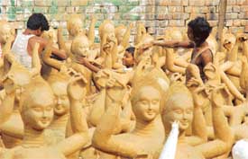 Idols of Goddess Lakshmi are being crafted by artists at the roadside on the Sherpur Road