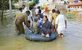 Chennai fire service personnel help a family after water entered their house in Velachery, South Chennai, following heavy rain on Saturday. 