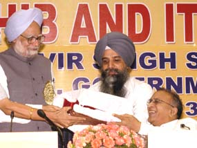 Prime Minister Manmohan Singh presents the first copy of the German translation of Guru Granth Sahib to Information and Broadcasting Minister Jaipal Reddy during the international seminar on Guru Granth Sahib in New Delhi on Sunday.