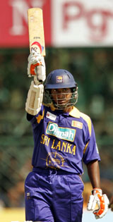 Sri Lankas Kumar Sangakkara raises his bat after completing his century against India during their third one-day international in Jaipur on Monday