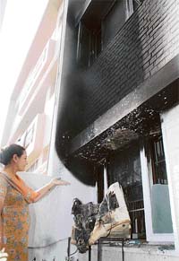 A resident of Phase-IV, Mohali, shows the aftermath of fire at her residence