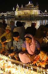 Devotees light candles on the occasion of Divali at the Golden Temple on Tuesday. 