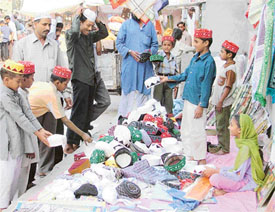 Children buy caps from a stall on the eve of Id-ul-Fitr in Ludhiana on Thursday