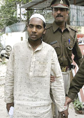 Policemen escort Mohammad Nawab towards  Indirapuram police station, Ghaziabad, on Thursday for questioning in the wake of bomb blasts which struck New Delhi on October 29. A day after sketches of a suspect in the blasts were released, the police detained Nawab, who bears an alleged resemblance to the sketches.