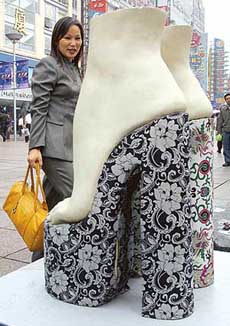 A Chinese shopper looks at a shoe sculpture that is part of a fashion and art exhibition in Shanghai on Friday. The European Union is preparing new anti-dumping tariffs on China's leather and reinforced shoes in a bid to control the country's booming exports following investigation which found that Chinese exporters were dumping footwear by selling these below the production cost. 