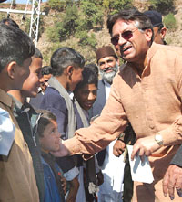 Pakistan President Pervez Musharraf presents gifts to Kashmiri children at a makeshift tent camp in Muzaffarabad on Friday.