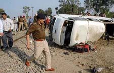 Jalandhar SSP Ishwar Singh inspects the mangled remains of a school van hit by a train at an unmanned crossing near Noormahal town in Jalandhar district on Saturday