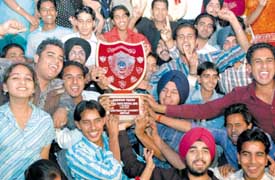 Jubilant students of APJ College of Fine Arts hold the trophy they had won on the concluding day of the GNDU Zonal-A youth festival at the Ladhewali regional campus, Jalandhar, on Saturday