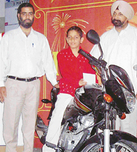 Eleven-year-old Snehul Thakur receives a Honda Unicorn motor cycle from Mr J.S. Jolly, business and operations head, Fun Republic, Chandigarh.