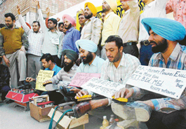Unemployed elementary teachers of Punjab polish shoes in support of their demands in Sector 17, Chandigarh, on Sunday.