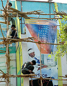 Workers engaged in creating a facsimile of the Technology Development at the Haryana Pavilion in Pragati Maidan