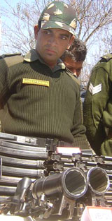 An Army jawan displays arms, ammunition and explosives recovered in two separate operations in the area around Rewari Baihk in the Gund Rishi Forest of Tangdhar Sector of Kupwara district, about 150 km from Srinagar
