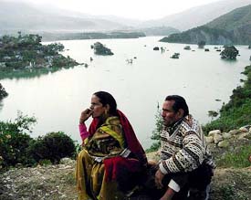 A couple watch helplessly as Old Tehri town sinks into the water of the Bhagirathi following closure of the T-2 tunnel of the 2400 mw Tehri hydel project, in Tehri on Sunday