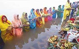 Women offer prayers to the sun god during Chhat puja at Sukhna Lake on Monday. Women observe a day-long fast during the festival, wishing for the betterment of their family and society.