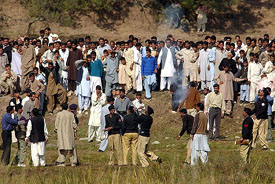 The Pakistani police lobs tear gas shells to check restive quake survivors from crossing the border at Tritinote village, Pakistan, on Monday. They had gathered to catch a glimpse of their dear ones living in Jammu and Kashmir. 