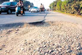 Potholed G.T. Road at a traffic light in Hargobind Nagar in Phagwara