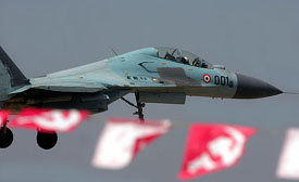 An Indian Air Force aircraft flies past Communist party flags at the Kalaikunda air base, 130 km west of Kolkata, on Monday. Thousands of activists from the Communist Party of India gathered outside the air base to protest against the joint Indo-US exercise, named Cope India 2005. 