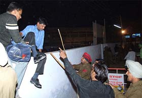Policemen prevent youths from scaling walls of sports stadium ahead of Gurdas Manns programme in Bathinda