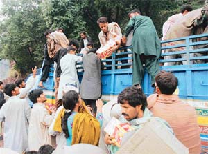 Social workers distribute relief among people affected by the recent quake
