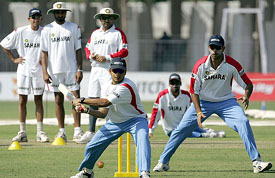 Murali Kartik plays a shot while his team-mates look on during a practice session in Rajkot on Tuesday