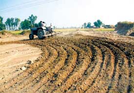 Furrowed mound: A tractor ploughs the historical theh in Bhala village. 