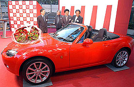 Mazda engineers stand with Mazda Roadster after it was voted the Car of the Year Japan, 2005-06, in Tokyo