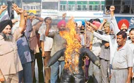 Members of the Punjab Government Transport Workers Union burn an effigy of Chief Minister Amarinder Singh in Ludhiana on Friday